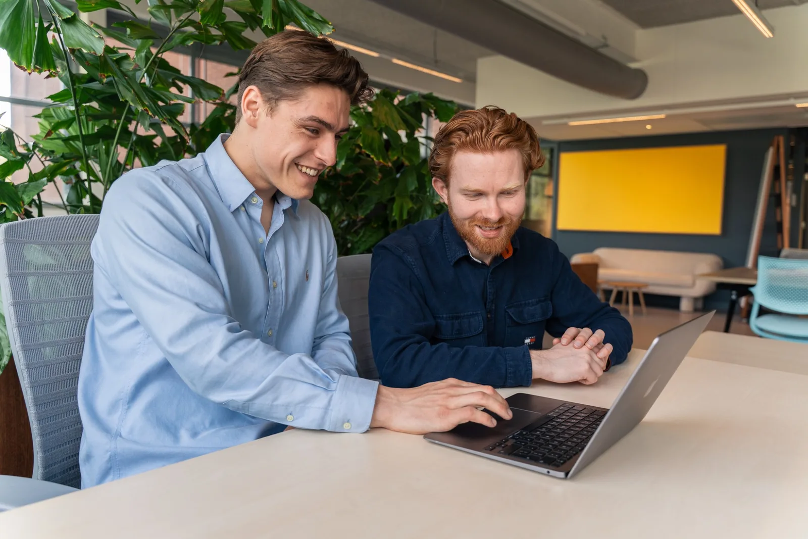 Robert en Tom van BizzPower werken samen achter een laptop